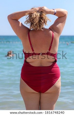 Girl in a swimsuit on the beach near the sea.