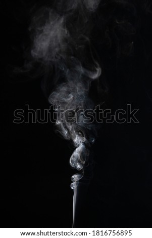 Abstract smoke moves on a black background with incense
