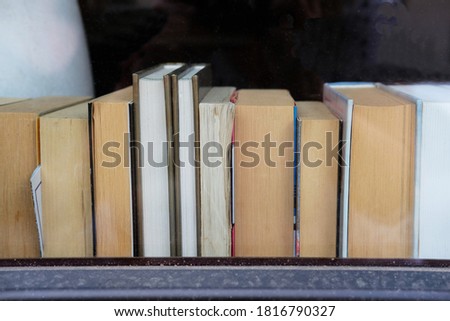 Old books on a windowsill of a cafe. Concept photo illustrating intellgence and learning. Copy space