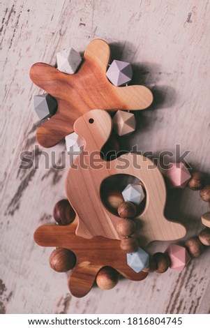 Cute wooden baby toys on the wooden background. Stars, planet and turtle toy. Eco accessories, beanbag and teethers for newborn. Flat lay, top view