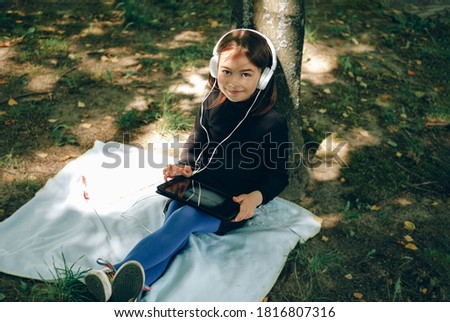 happy girl using digital tablet in the park