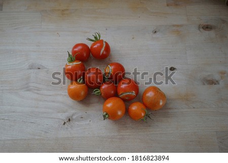  Bio Tomatoes jumped up from the rain they are lying on a wooden table