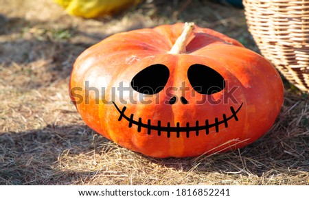 A large bright ripe pumpkin with a funny laughing face