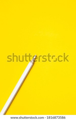 diagonal white sharp wooden pencil on a bright yellow background, isolated, copy space, mock up.