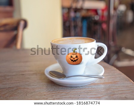 A happy Halloween Cup of coffee with a pumpkin spooky face 