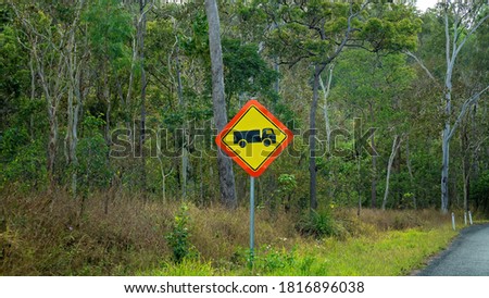 Truck icon roadside sign warning to beware of large vehicles using the road through bushland