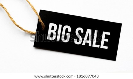 Text BIG SALE on a black tag on a white paper background