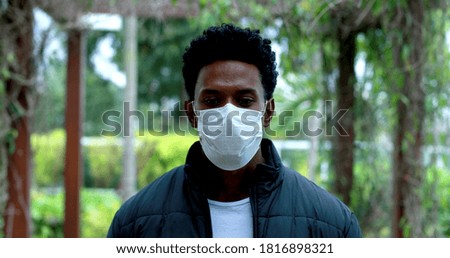 African man walking wearing pandemic mask portrait.