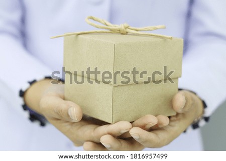 Close up shot of female hand holding gift box with blurred backgrounds