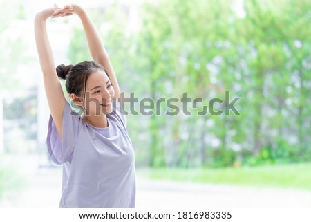 attractive asian woman stretching at living room Royalty-Free Stock Photo #1816983335