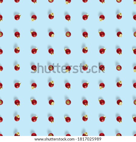 Seamless pattern with red Christmas decorations on blue background. Christmas abstract background made from balls. Christmas red ornaments Seamless pattern.