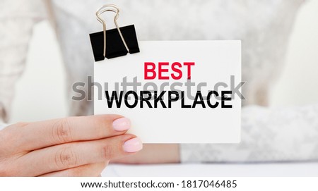 Closeup on businessman holding a card with text BEST WORKPLACE, business concept image with soft focus background and vintage tone