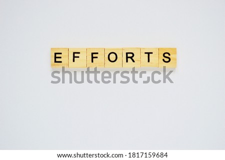 Word efforts. Top view of wooden blocks with letters on white surface