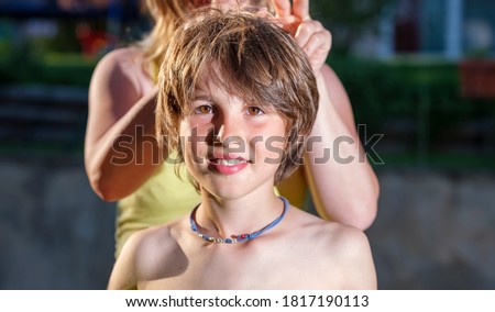 Portrait of a shirtless smiling child lit by the sun on a summer day.