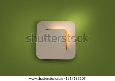 Lighted modern white lamp on green wall