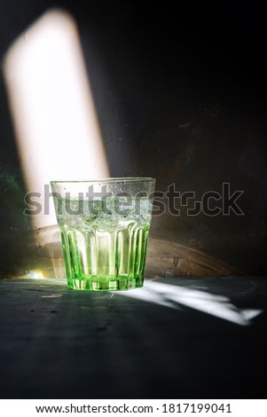 Glass of water on arustic backreound. with lighting effects