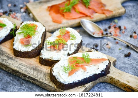 Healty keto salmon sandwiches with  flaxseed bread, spiced cottage cheese on  industrial background. Party food .Light office lunch