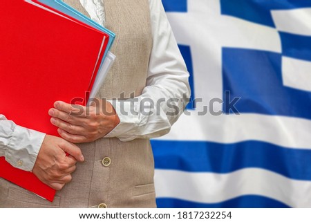 Woman holding red folder on Greece flag background. Education and jurisprudence concept in Greece