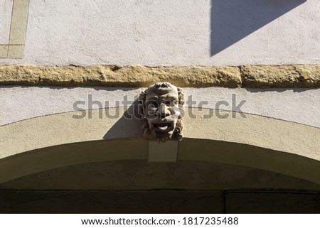 Italian anthropomorphic keystone on arc of XV century building closeup