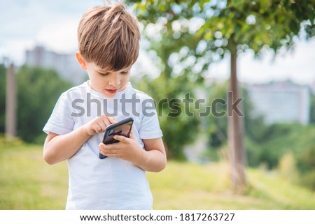 the child speaks on the phone in nature