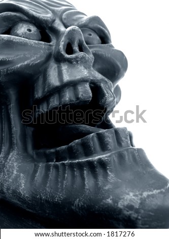 Ghoulish statue gargoyle face against sky background.