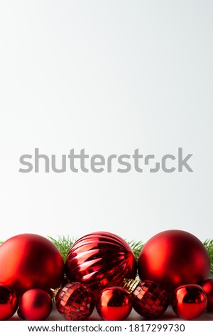Festive background from red textured Christmas balls and sprigs of fir. Postcard with space for writing text.
