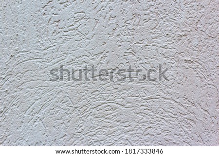 Decorative white wall plaster pattern stylized in bark beetle texture. The white texture of the surface of the wall covered with decorative plaster of the woodworm type, close-up abstract background