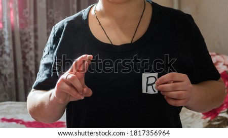 The English letter R in sign language.
