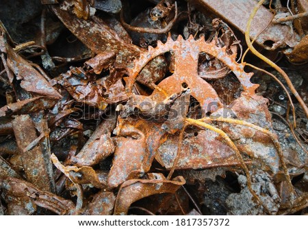 Pile of old rusty scrap metal ready for recycling. Sheet metal, wires and gear wheel closeup.