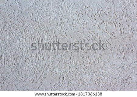 Decorative white wall plaster pattern stylized in bark beetle texture. The white texture of the surface of the wall covered with decorative plaster of the woodworm type, close-up abstract background
