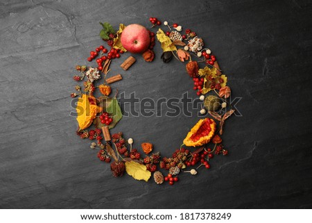 Dried flowers, leaves and berries arranged in shape of wreath on black background, flat lay with space for text. Autumnal aesthetic