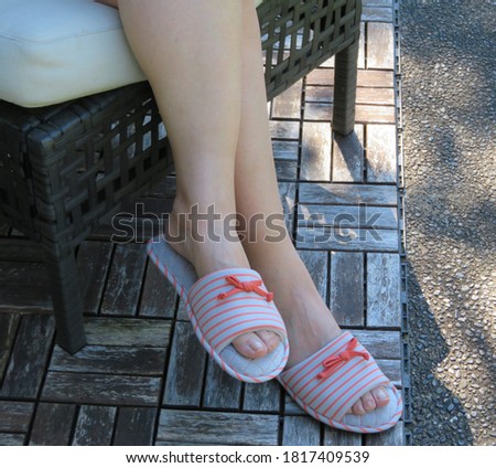 Photo of woman feet in slippers sitting on couch relaxing at home backyard