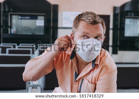 Close-up of a man with a surgical mask on his face.