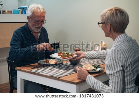 Beautiful mature - senior couple have romantic dinner at home stock photo