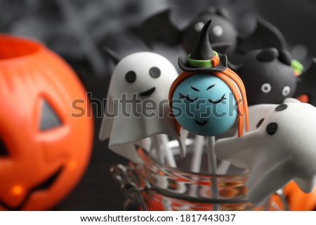 Different Halloween themed cake pops on dark background, closeup