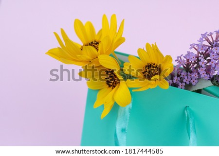 wild flowers, yellow and lilac in a gift bag, greeting concept, gift. space for text.