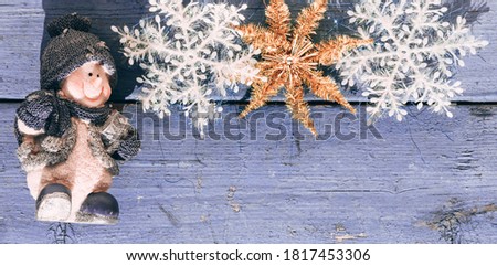 Beautiful lilac Christmas banner with a snowman, white snowflakes and a Golden shiny star. Wooden Christmas background, top view. Place for text on a new year's background.