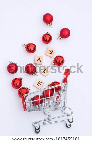 Grocery basket with red balloons and letters.The inscription in English: "sale".Christmas online shopping.Winter holiday sales, seasonal sales, Black Friday, Christmas, discounts, and shopping on site