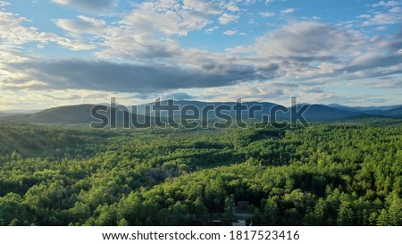 Aerial scenic mountain sunrise. Beautiful blue sky with clouds over the Maine mountain range with early morning sunshine