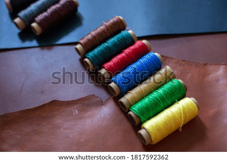 Colorful leather thread working on genuine leather background craftsmanship