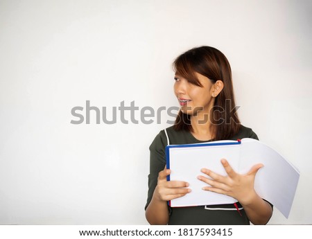 Lady wearing braces.holding book in hand,looking to the left side and smile,model posing