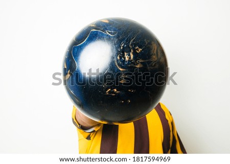 Selective focus picture of bowling ball been lifted by a men on isolated white background.