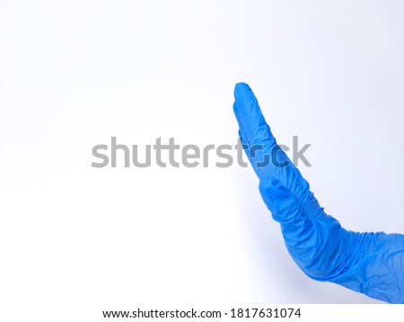 A hand with blue latex glove, refuse sign. Isolated on white background. Side view