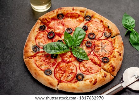 pizza margarita with basil on a stone background