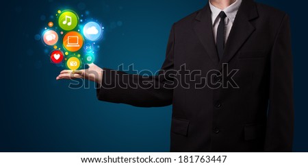 Young business man in suit presenting colorful technology icons and symbols