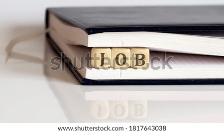 JOB on wooden cubes in notepad on the white background