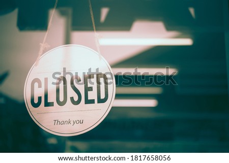 Text on white sign board  “Closed” infront of the mirror’s  shop . This shop was dark and  closed beacuse of the bankrupcy. 
