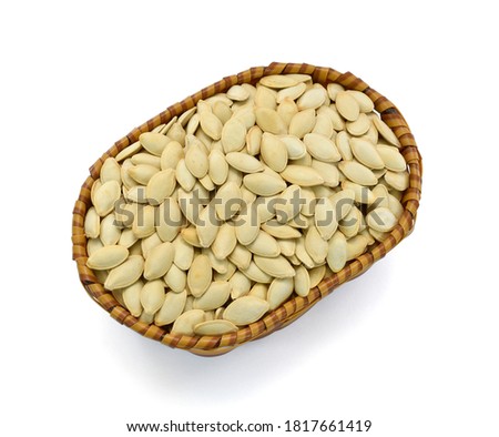 Roasted pumpkin seeds in basket isolated on white background