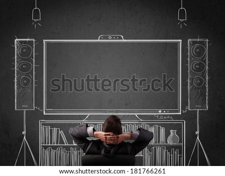Young businessman sitting and enjoying home cinema system sketched on a chalkboard Royalty-Free Stock Photo #181766261