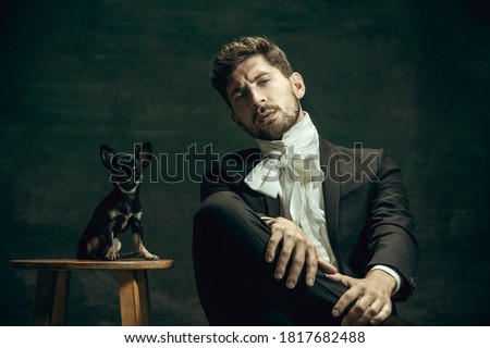 Young man in suit as Dorian Gray isolated on dark green background. Retro style Royalty-Free Stock Photo #1817682488